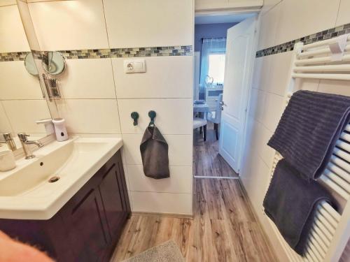a bathroom with a sink and a towel hanging on the wall at Panoráma Garden in Zalakaros