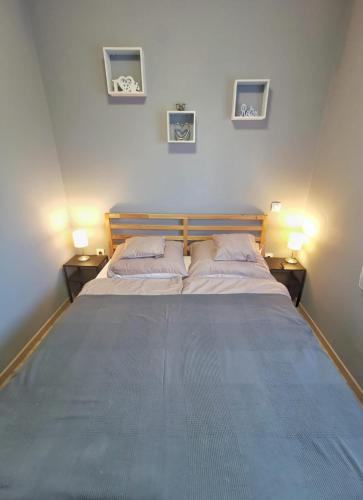 a bedroom with a large bed with two lamps on two sides at Panoráma Garden in Zalakaros