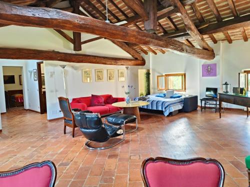 ein Wohnzimmer mit einem roten Sofa und einem Tisch in der Unterkunft Villa Gattoni Cattaneo - Appartamento Le Magnolie in Lardara