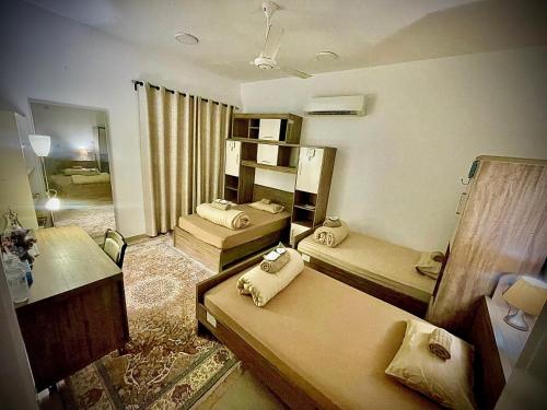 Habitación con 2 camas y espejo. en نزل الشاطئ, en Ḩayl Āl ‘Umayr