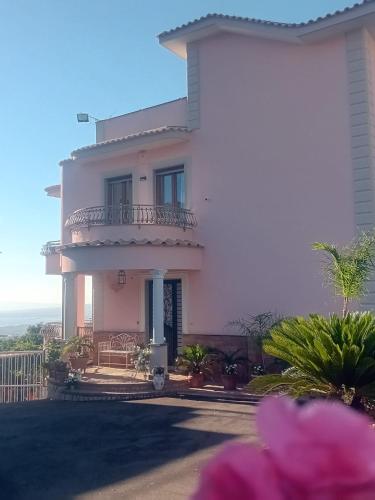 a large pink house with a balcony on top of it at La Vigna del Vento in Casola di Napoli
