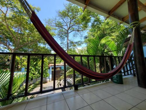 a hammock on the balcony of a house at Dylan’s Surf Inn in La Libertad