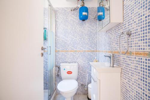 ein blau gefliestes Bad mit WC und Waschbecken in der Unterkunft XiangBaLa in Athen