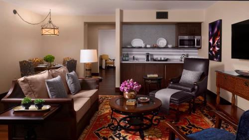 a living room with a couch and chairs and a kitchen at Plaza la Reina in Los Angeles