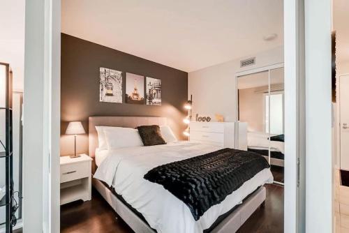 a bedroom with a large bed and a mirror at Beautiful 1BD 1BA Condo Lake and City Views in Toronto