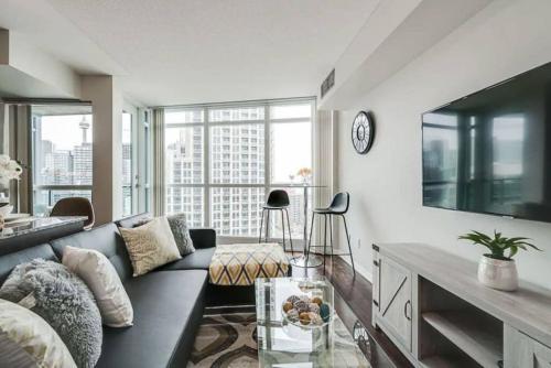a living room with a couch and a tv at Beautiful 1BD 1BA Condo Lake and City Views in Toronto