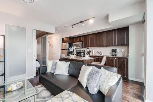 a living room with a couch and a kitchen at Beautiful 1BD 1BA Condo Lake and City Views in Toronto