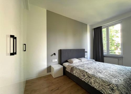een slaapkamer met een bed en een raam bij K22 Large Apart Slawinska 509 in Warschau