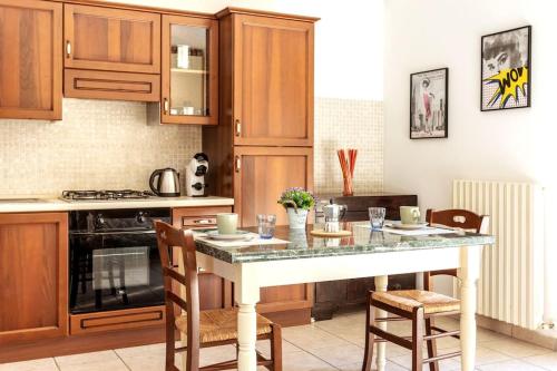 uma cozinha com armários de madeira e uma bancada de mármore em Casa dei quadri monolocale Jesi em Iesi