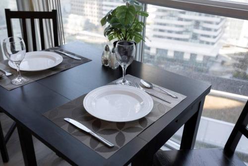 a black table with two white plates and glasses on it at Classy 1BR plus DEN w Amazing skyline view and WFH in Toronto