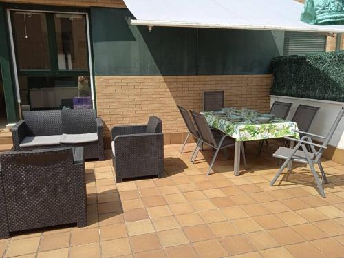 a patio with a table and chairs and a fireplace at Apartamento L' Espumeru in Posada de Llanes