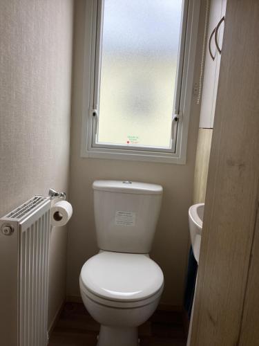 a bathroom with a white toilet and a window at Staycation For You (Kent) in Leysdown-on-Sea