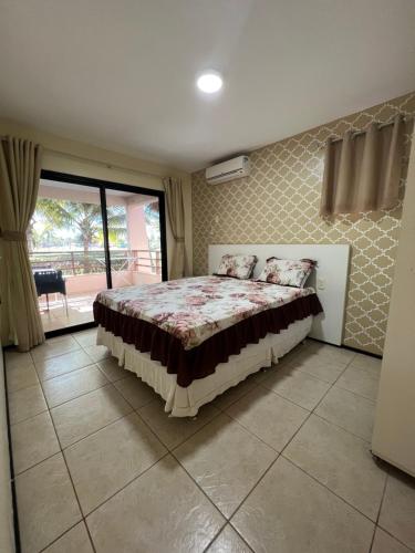 a bedroom with a bed and a balcony at Apartamento Aquaville Resort in Aquiraz