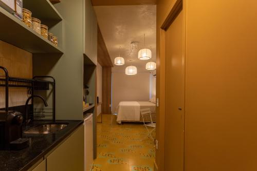 a kitchen with a hallway with a bed in a room at Studio Savana in São Paulo