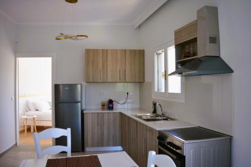 a kitchen with a refrigerator and a table and chairs at Tarmaros - Families & Groups in Sissi
