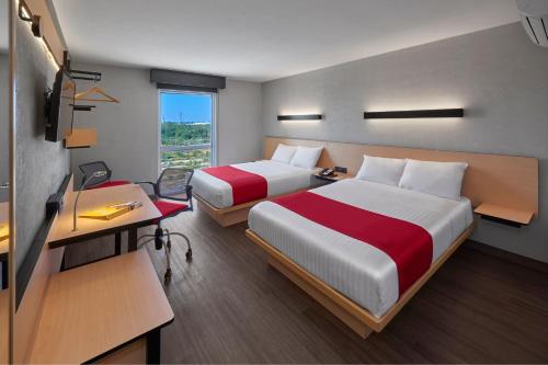 a hotel room with two beds and a desk at City Express by Marriott Reynosa Aeropuerto in Reynosa