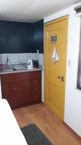 Una puerta amarilla en una cocina con fregadero en Historic Centre Premium Quality Lodging, en Quito