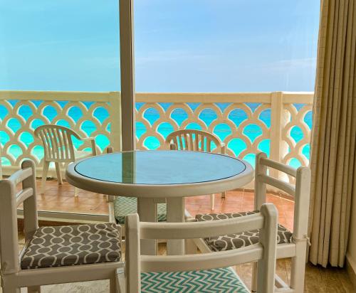 a glass table and chairs on a balcony at BOF Apartments Cancun in Cancún