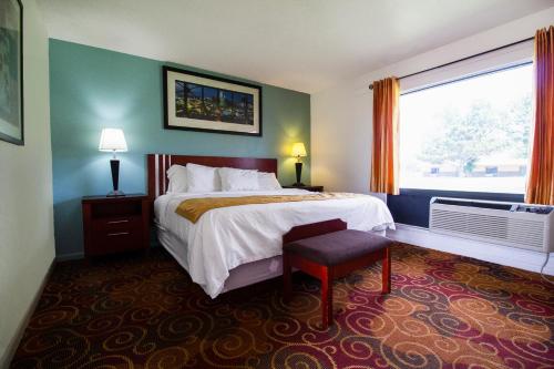 una camera d'albergo con letto e finestra di American Best Inn By OYO I-35 Perry near Lake McMurtry a Perry