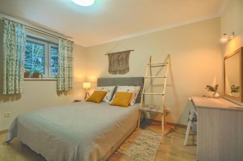 Un dormitorio con una cama con almohadas amarillas y una escalera en Przystanek Leśna en Targanice
