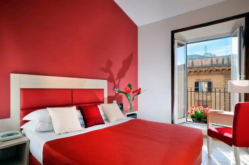 - une chambre rouge avec un lit et un mur rouge dans l'établissement Hotel Scott House, à Rome
