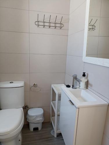 a white bathroom with a toilet and a sink at La pinza bl am in El Palmar