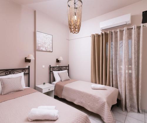 a bedroom with two beds and a chandelier at Filia Apartments in Pitsidia