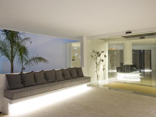 - un salon avec un canapé et un palmier dans l'établissement HM Balanguera Beach - Adults Only, à Playa de Palma