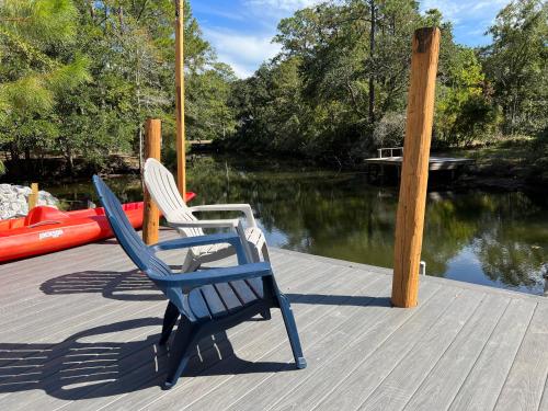 two chairs sitting on a dock next to the water at Waterfront Newly Renovated and Decorated 3brs home in Milton