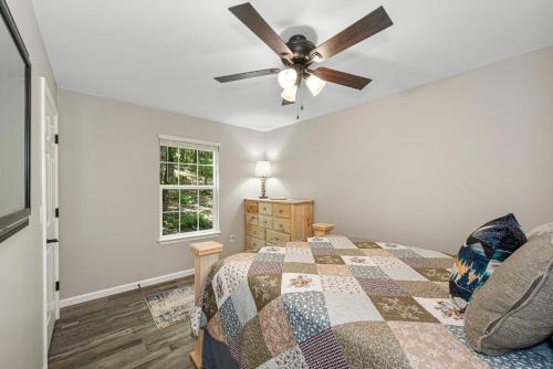 Schlafzimmer mit einem Bett und einem Deckenventilator in der Unterkunft Coyote Cabin at Woodland Retreat at DeSoto beside DeSoto State Park in Fort Payne