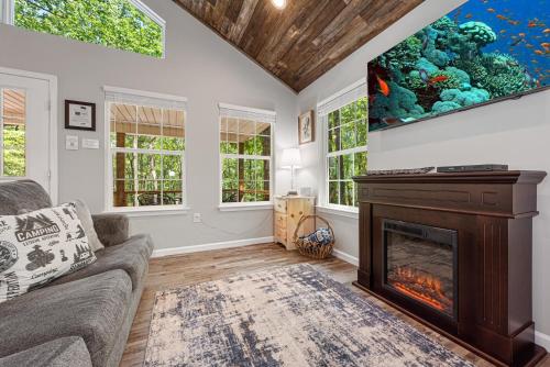 Una sala de estar con chimenea y un acuario en la pared. en Coyote Cabin at Woodland Retreat at DeSoto beside DeSoto State Park, en Fort Payne