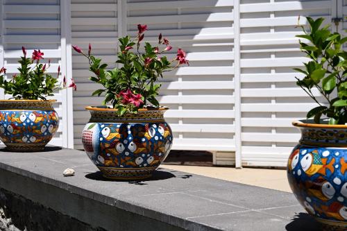 three vases with flowers in them sitting on a wall at Paradisea Taormina in Taormina