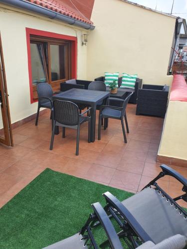 a patio with black tables and chairs and a green rug at Terraza Mirador in A Coruña