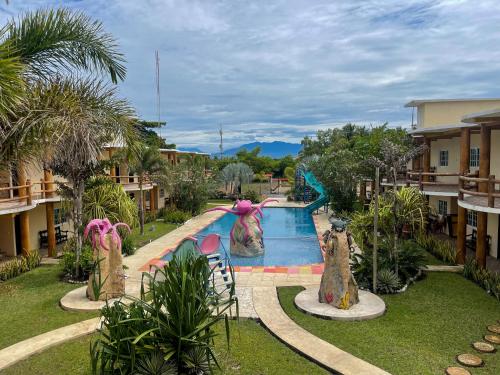 a resort with a swimming pool with statues of animals at Hotel Pazifico en Monterrico in Monterrico