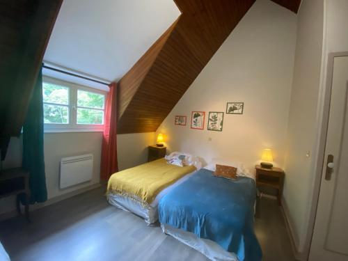 een slaapkamer met een bed op zolder bij ÉCO-VILLAGE Les Moulins du Duc in Moëlan-sur-Mer