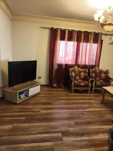 تحسين فرغلي في القاهرة: غرفة معيشة مع تلفزيون بشاشة مسطحة وأريكة
