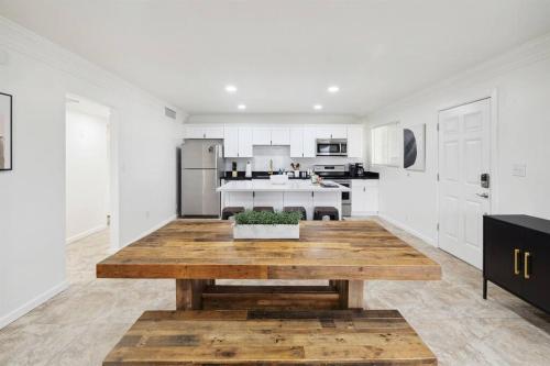 a white kitchen with a wooden table in the middle at Home 8 Minutes to Old Town Scottsdale in Scottsdale