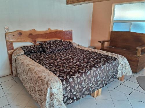 a bedroom with a bed with a wooden headboard and a window at Villas la Quinta (etapa Aserradero) in Creel