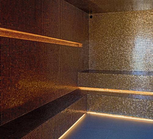 a bathroom with a tub and a tiled wall at Hotel Fasano Sao Paulo Itaim in Sao Paulo