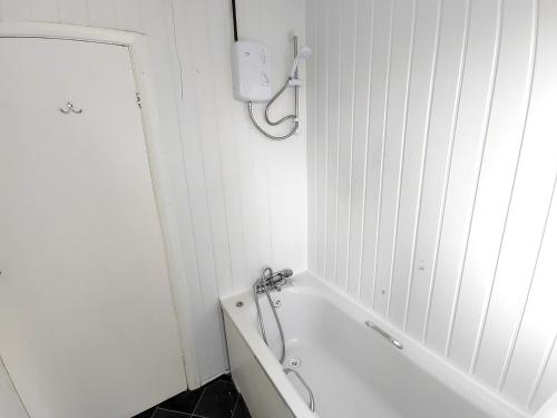 a white bathroom with a bath tub and a sink at Browning House in Lincoln