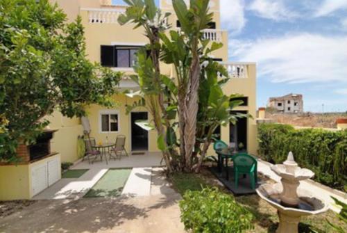 una casa con una palmera en el patio en Apartamentos Paradise Fuseta, en Fuseta