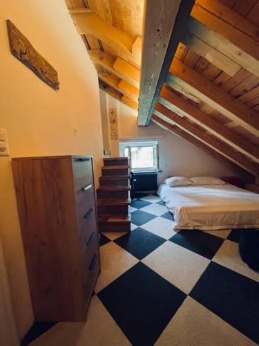 a bedroom with a bed and a checkered floor at Sottotetto grazioso St.Moritz in St. Moritz