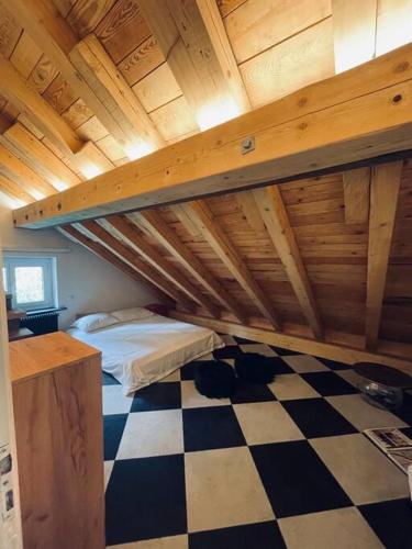 a attic room with a bed and a checkered floor at Sottotetto grazioso St.Moritz in St. Moritz