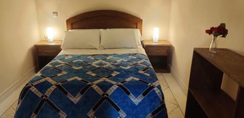 - un lit dans une chambre avec 2 tables de nuit et 2 bougies dans l'établissement Araucaria, à Essaouira