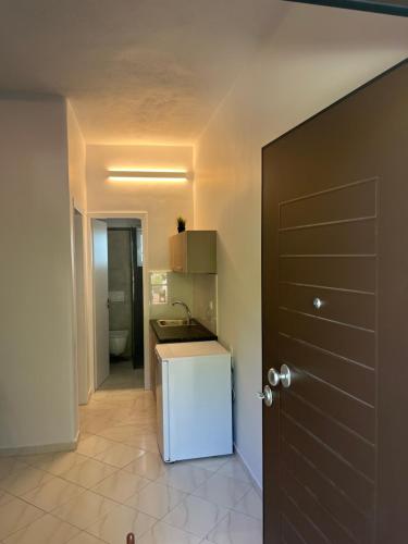 a kitchen with a white refrigerator next to a door at Krinides Place in Nerotriviá