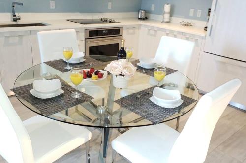 a glass table with a bowl of fruit and wine glasses at Gorgeous Upscale Condo in the Middle of Brickell in Miami