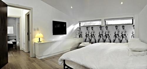 um quarto com uma cama branca com uma parede com esqueletos em THE EDGE - Architect Designed - by Crown Gardens Holiday Homes em Brighton & Hove