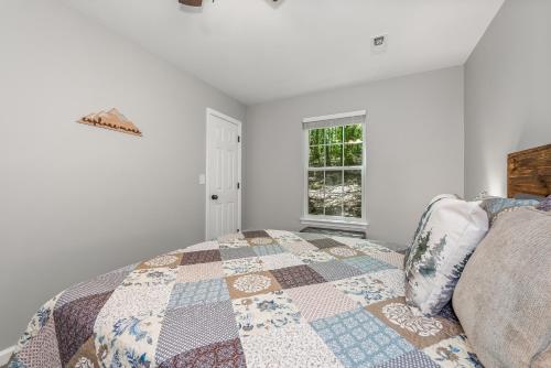 a bedroom with a bed with a quilt on it at The Otter Box Cabin - 92 Acres Beside DeSoto State Park in Fort Payne