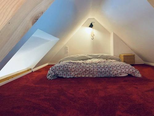 a bedroom with a bed in a attic at Studio à la ferme 