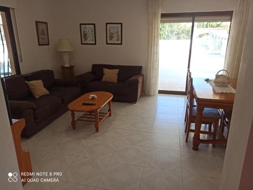een woonkamer met een bank en een tafel bij Villa Chalet Riomar Playa Oliva in Oliva